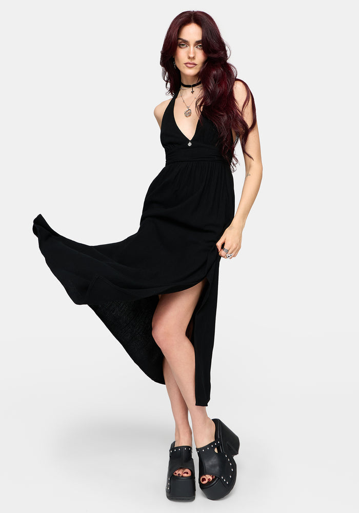 Woman wearing a floaty black dress on a white background